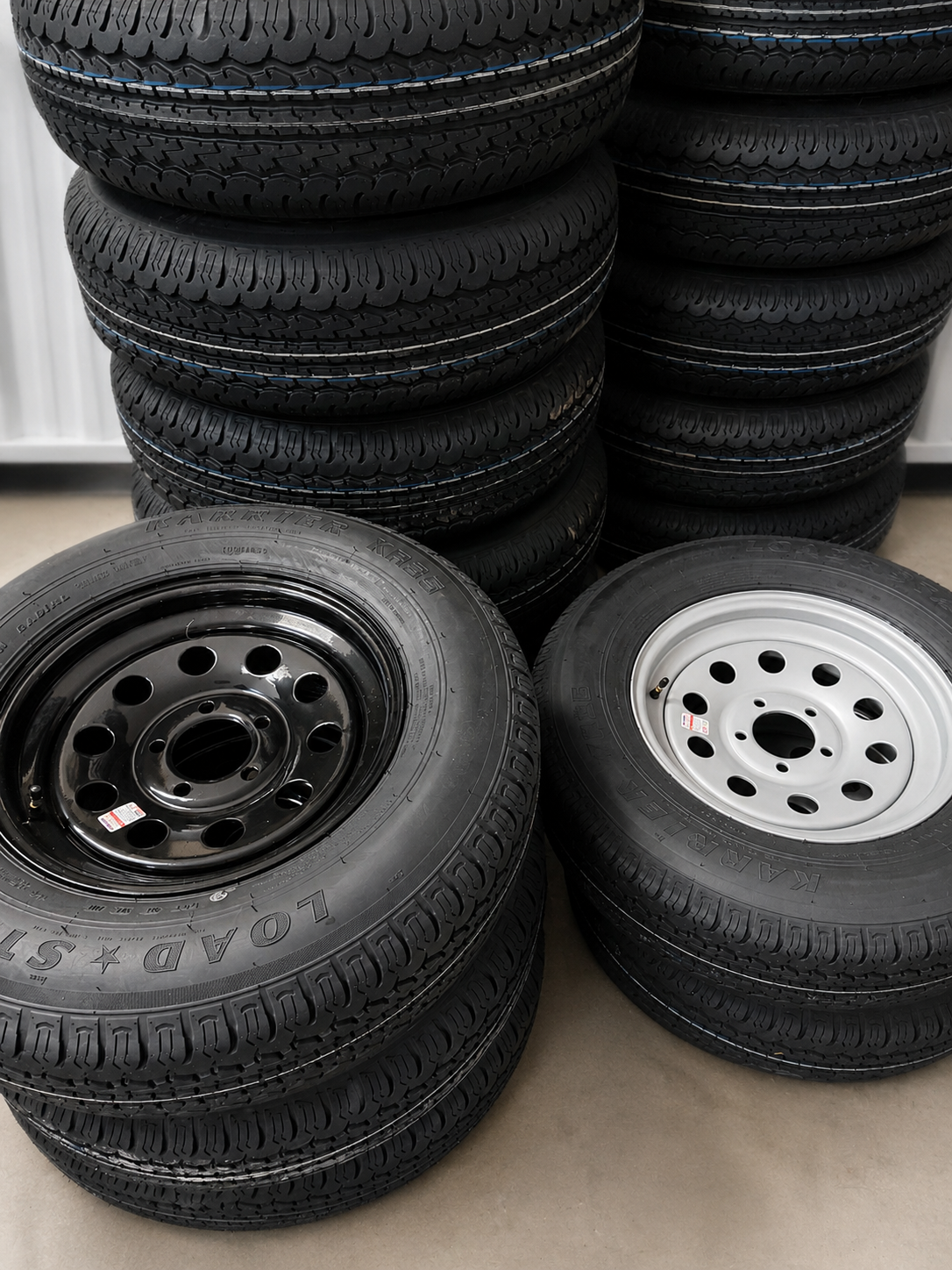 Stacked trailer tires and tire-and-rim combos in stock at Madison Trailer Rentals